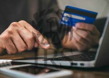 Person using a credit card on a laptop to make an online purchase