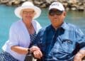 A retired couple enjoying the outdoors by the sea, representing retirement and well-being in old age