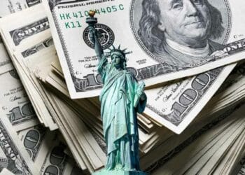 Stacks of $100 bills and the Statue of Liberty, representing unclaimed funds in New York.