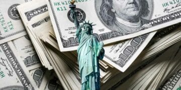 Stacks of $100 bills and the Statue of Liberty, representing unclaimed funds in New York.