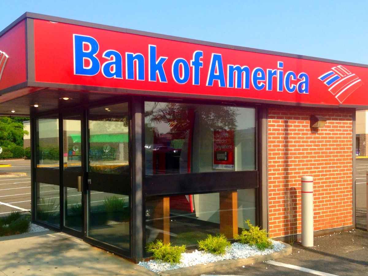Small standalone Bank of America branch with bright red signage in an empty parking lot, illustrating the bank’s recent U.S. branch closures