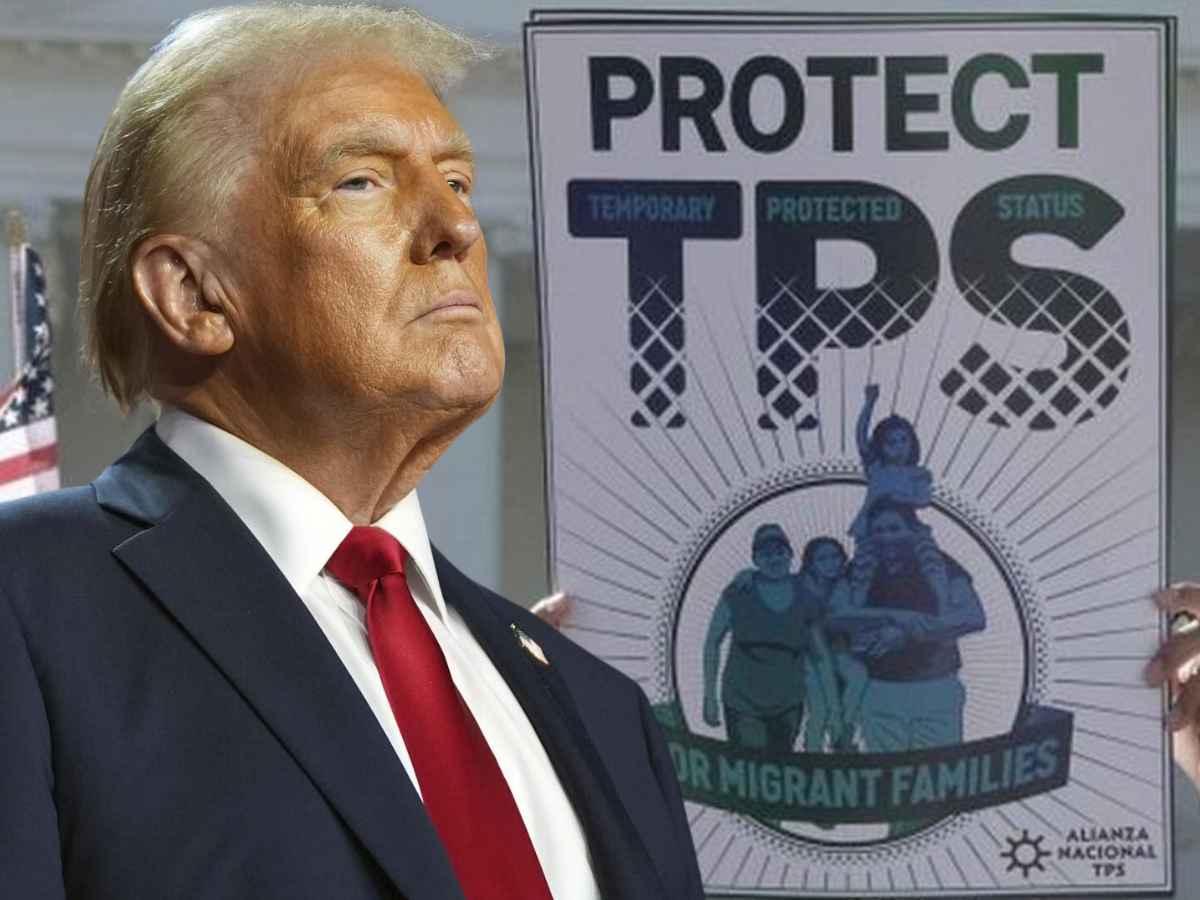 Suited man with red tie stands in foreground while a poster that reads “Protect TPS” and depicts a migrant family is displayed behind him