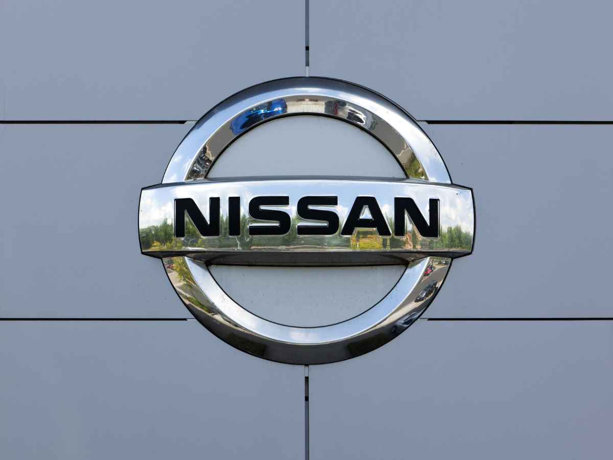 Nissan chrome logo on gray dealership facade, illustrating automaker’s NHTSA fine and 40,000-vehicle safety recall