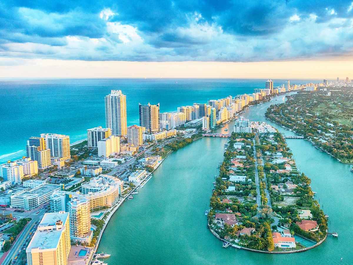 Aerial panorama of Florida beachfront skyline, turquoise Atlantic waters and winding canals symbolizing affordable retirement hot spots for budget-minded couples