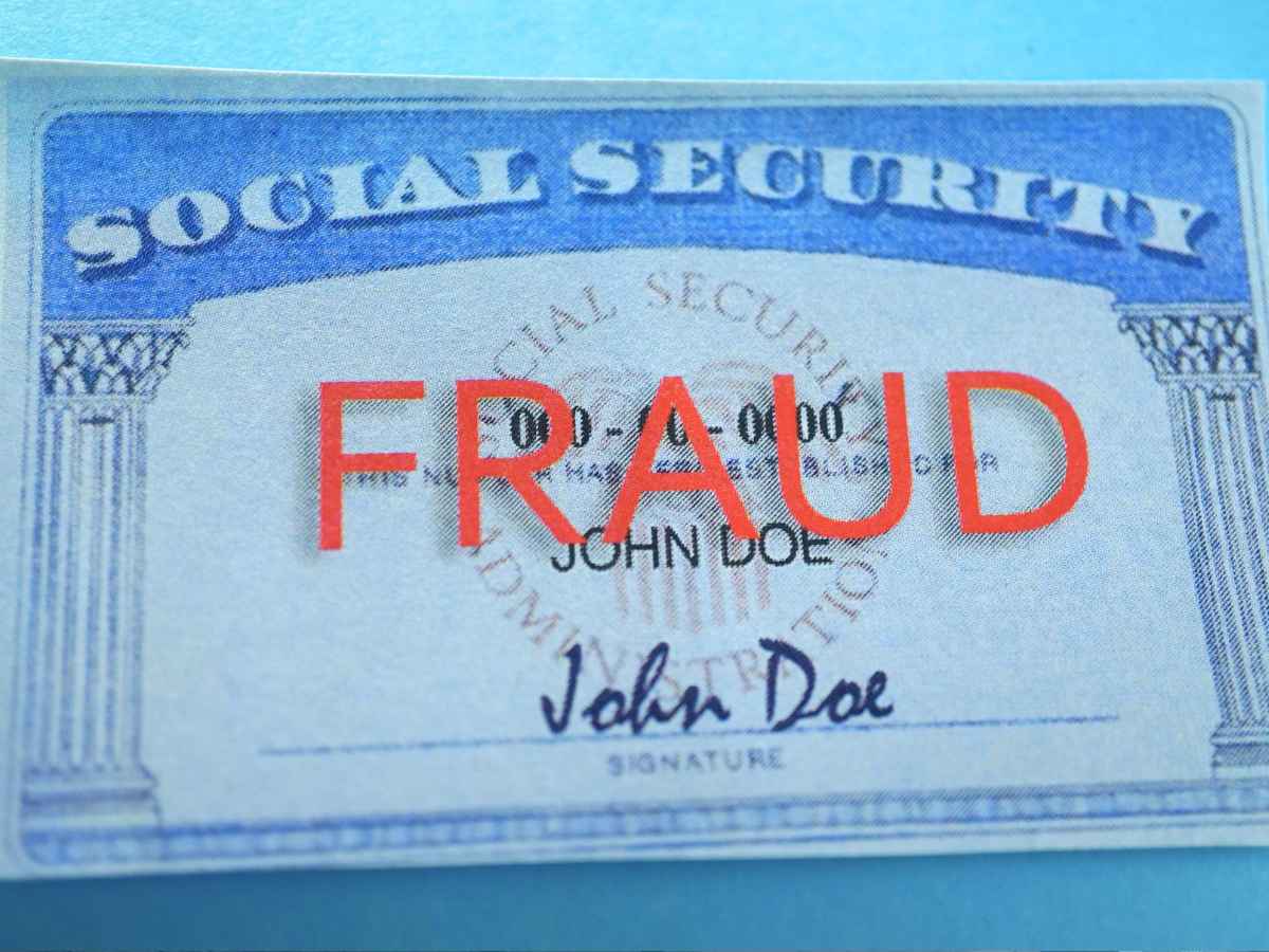 Social Security card with bold red “FRAUD” stamp highlighting SSA identity-verification crackdown and 1-800-772-1213 hotline
