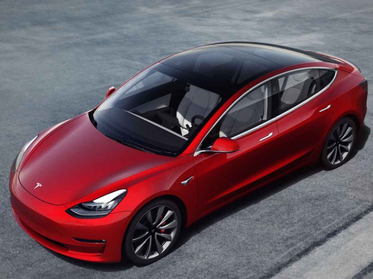 Red Tesla Model 3 parked on concrete, highlighting design and electric efficiency benefits