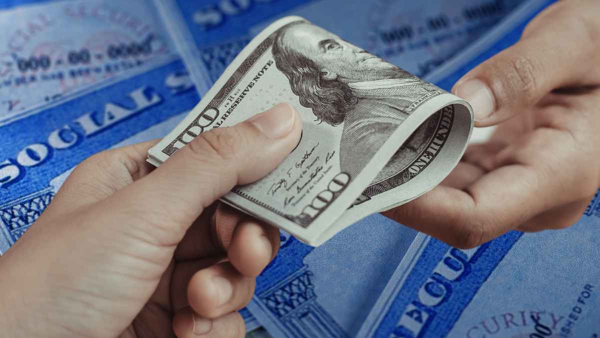 Hundred-dollar bills exchanged over Social Security cards, illustrating up to $2,831 May payments for eligible 62-year-olds