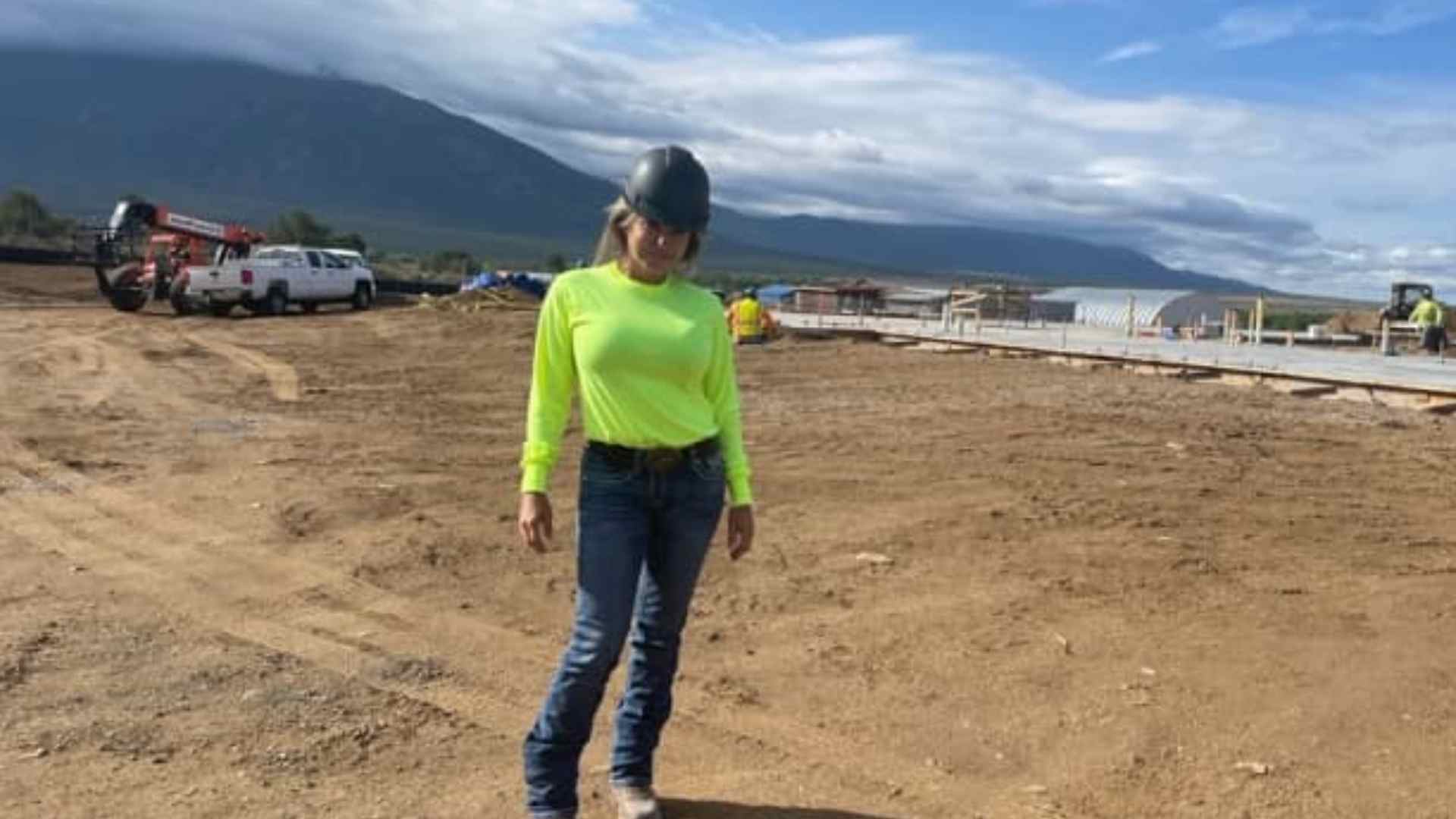 Bridgette Tena, a 51-year-old businesswoman wearing a hard hat and high-visibility T-shirt at a roofing job site in Santa Fe, New Mexico.