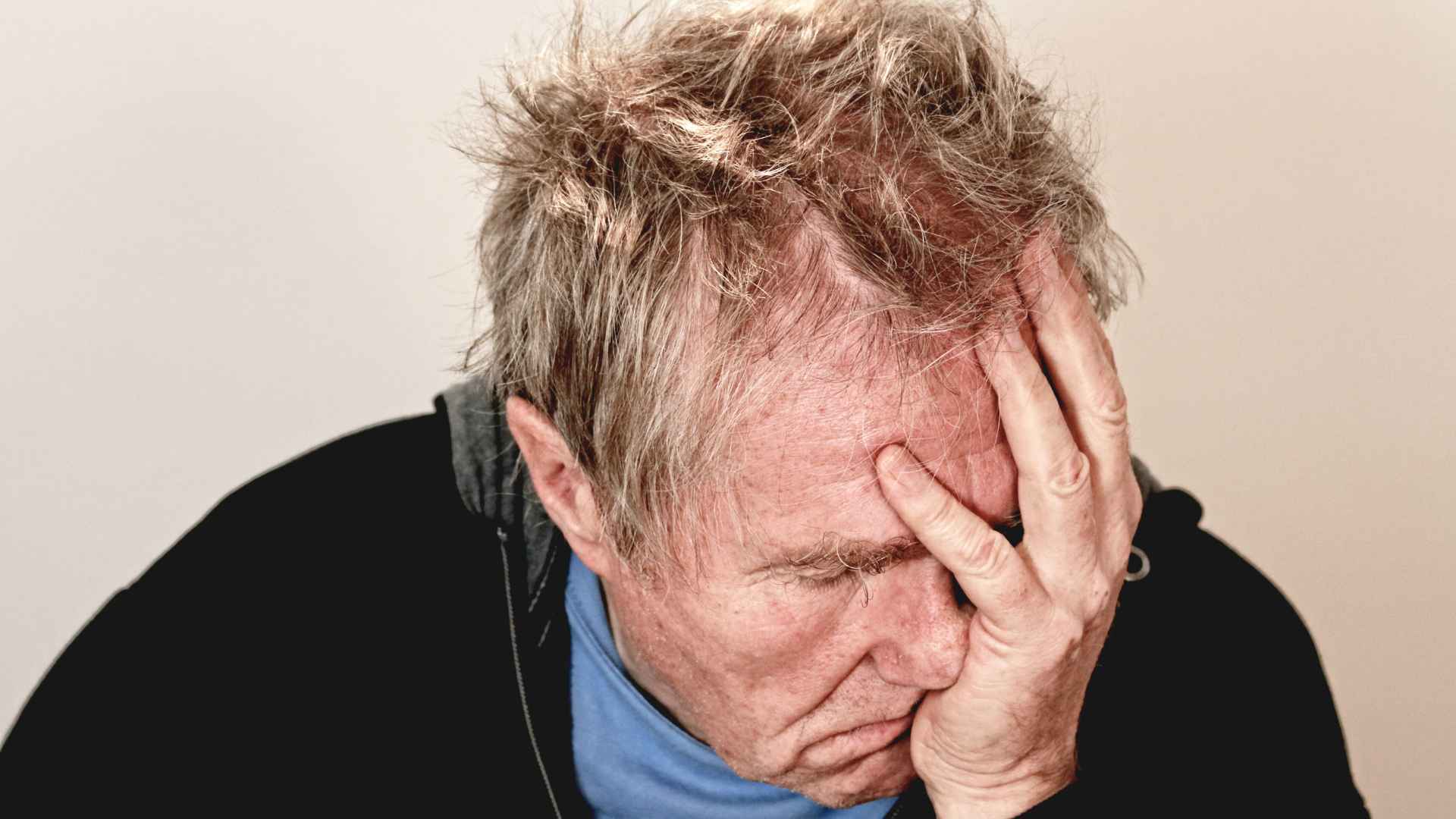 Elderly man holding his head in frustration over potential retirement savings seizure