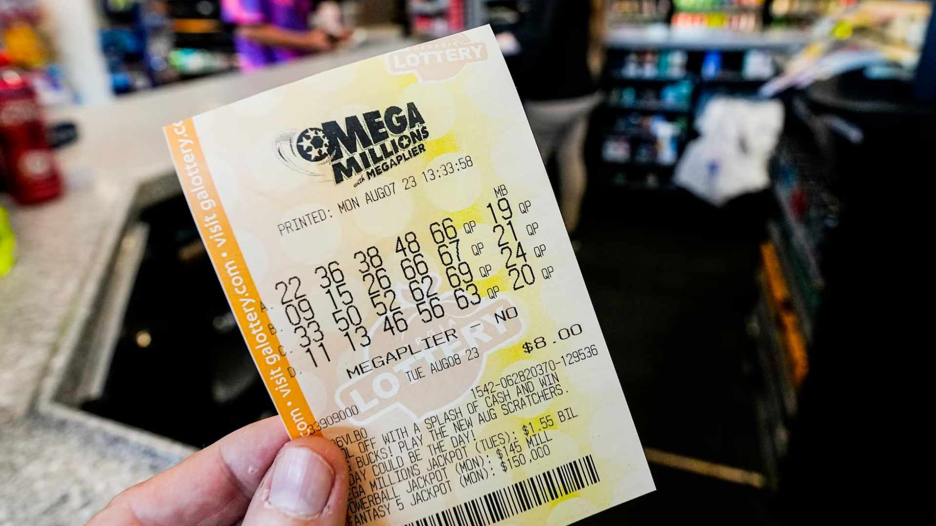 Close-up of a hand holding the $1.17 billion Mega Millions ticket sold at Sunshine Food and Gas in Cottonwood, California.