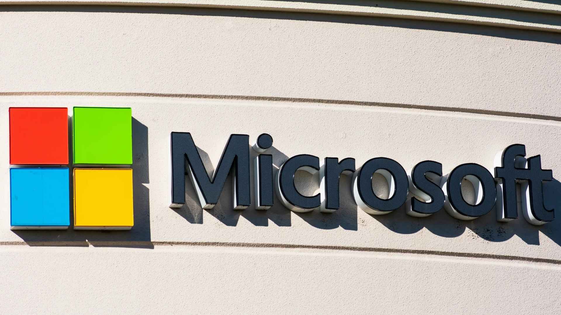 Microsoft logo on corporate building illustrating new $1.50 Windows hotpatch fee for no-reboot security updates launching July 1