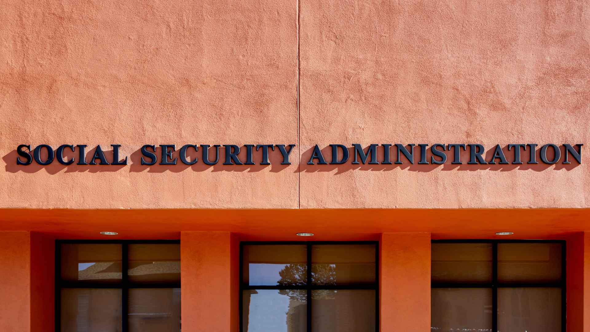 Social Security Administration office sign on a peach-colored facade, symbolizing where retirees must file an address-change notice before moving to another state.