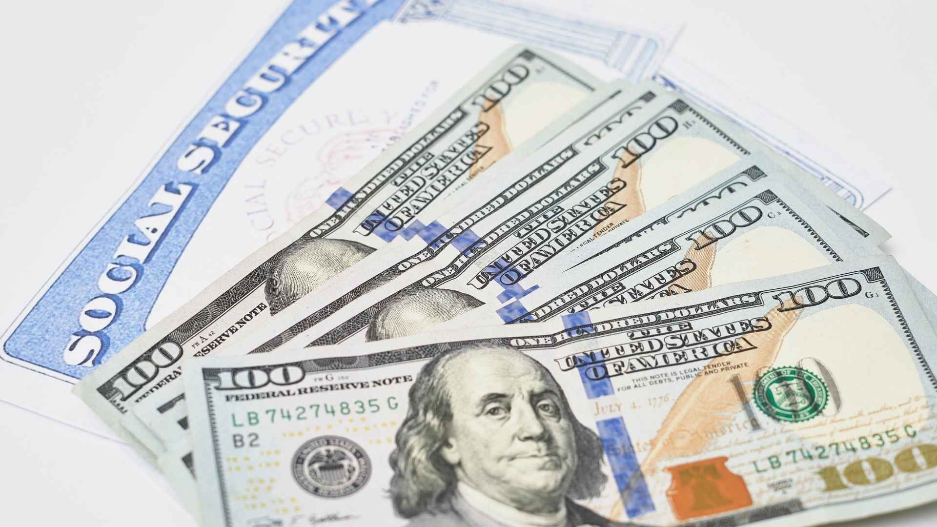 Stack of $100 bills on top of a Social Security card symbolizing lost monthly benefits if Login.gov update is ignored