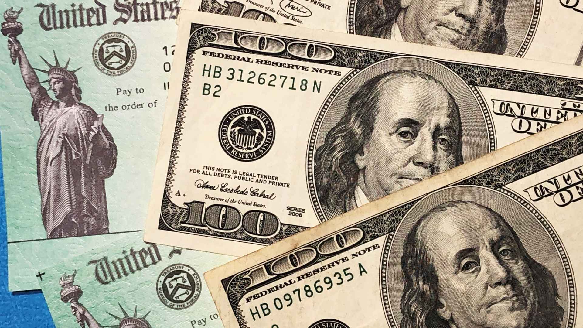 Social Security benefit check alongside U.S. hundred-dollar bills
