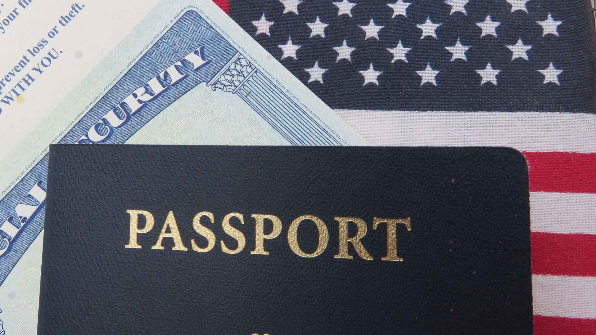 Close-up of a Social Security card and U.S. passport on an American flag, symbolizing senior benefits in the House tax bill debate.