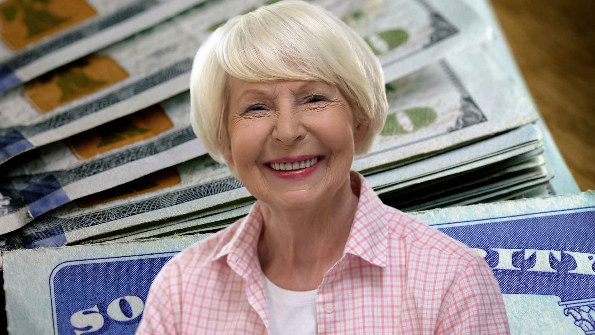 Smiling 62-year-old retiree with cash and Social Security card, illustrating potential $2,831 benefit arriving in June.