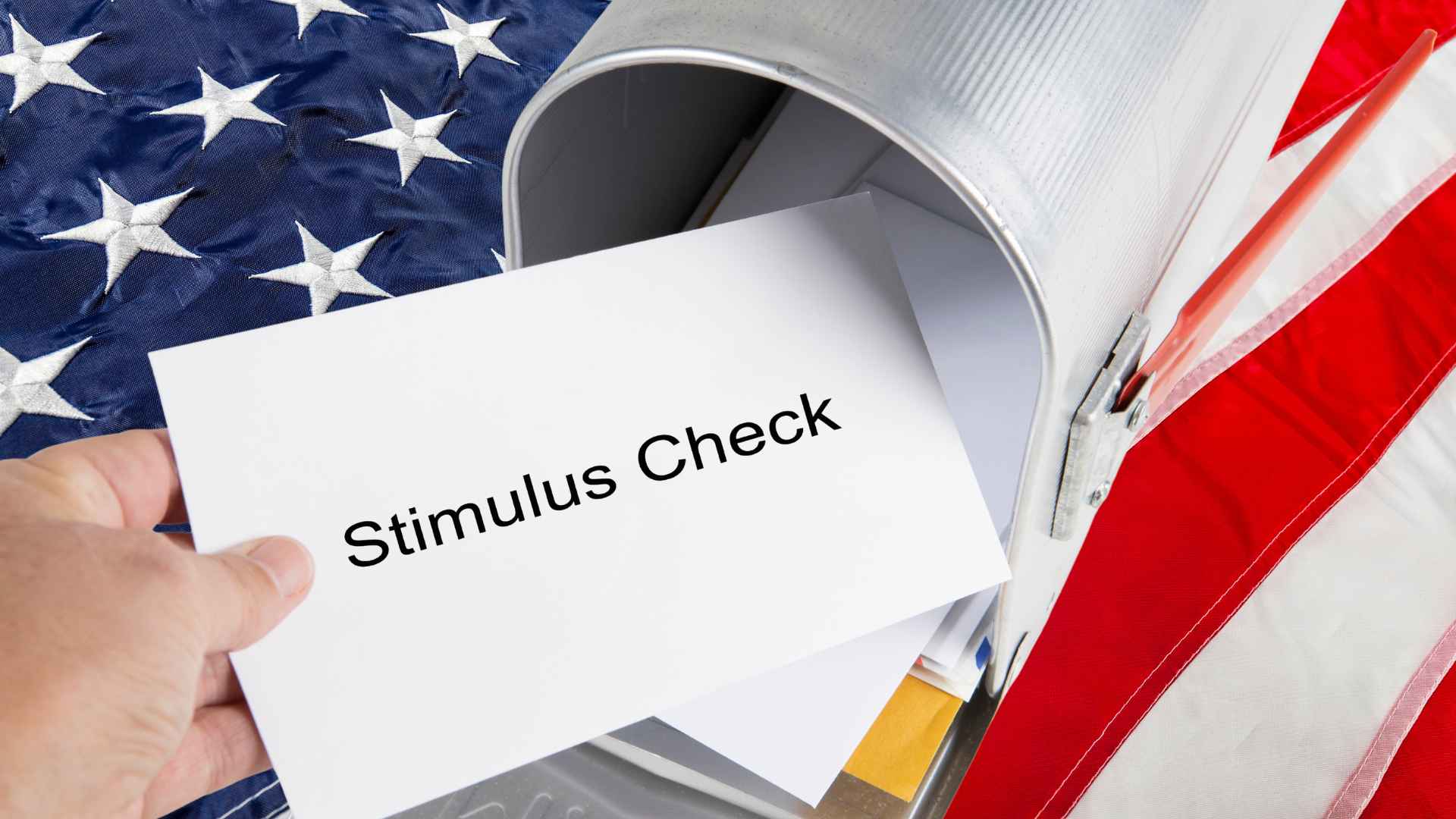 Person retrieving stimulus check from mailbox with American flag in background