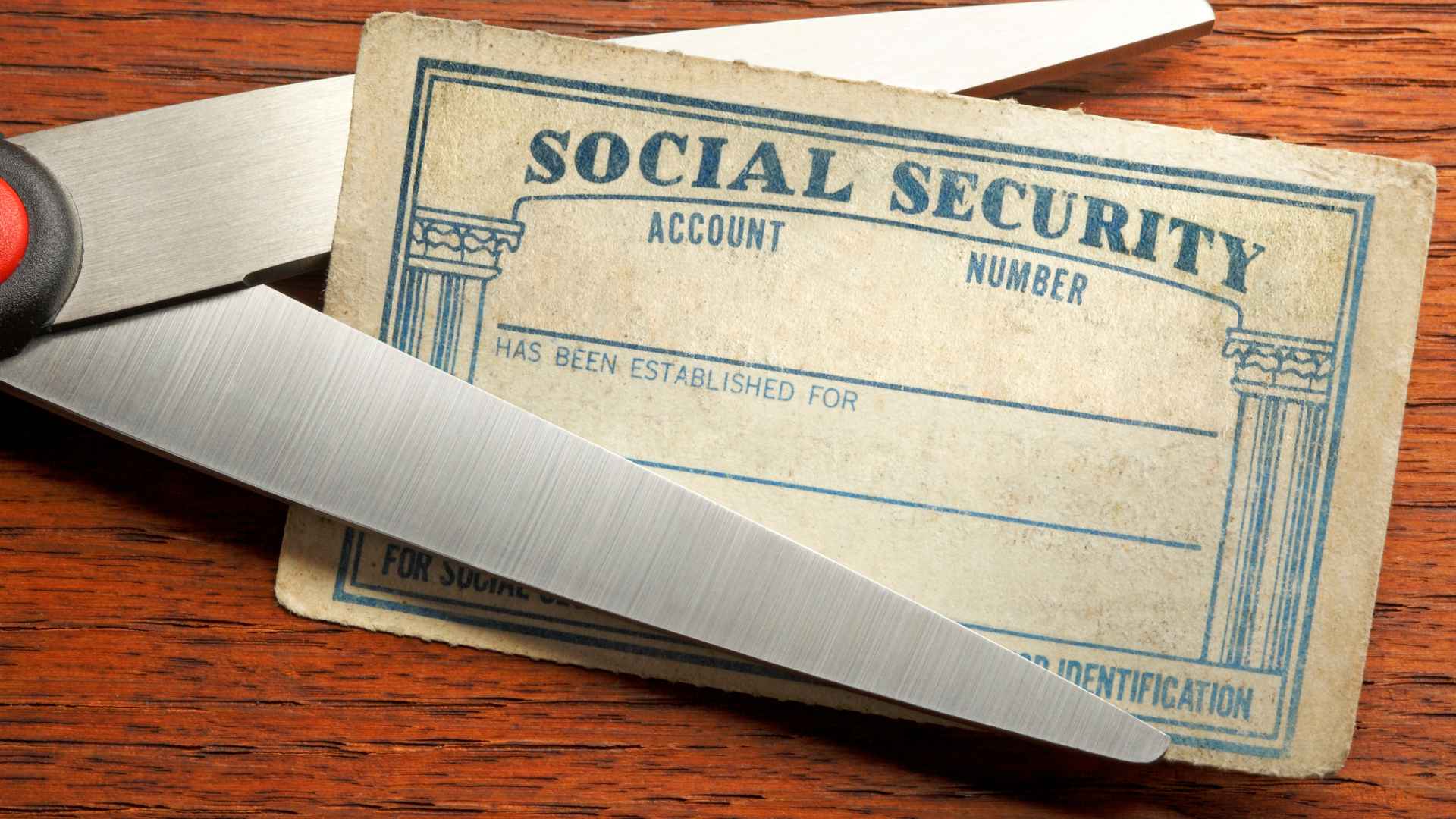 Scissors cutting a Social Security card, symbolizing the shift from paper benefit checks to secure automatic direct deposits.