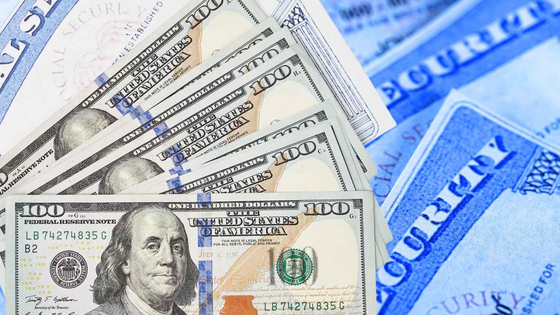 Stack of hundred-dollar bills lying on Social Security cards, illustrating the risk of lost benefits if recipients miss the 2025 SSA checklist.