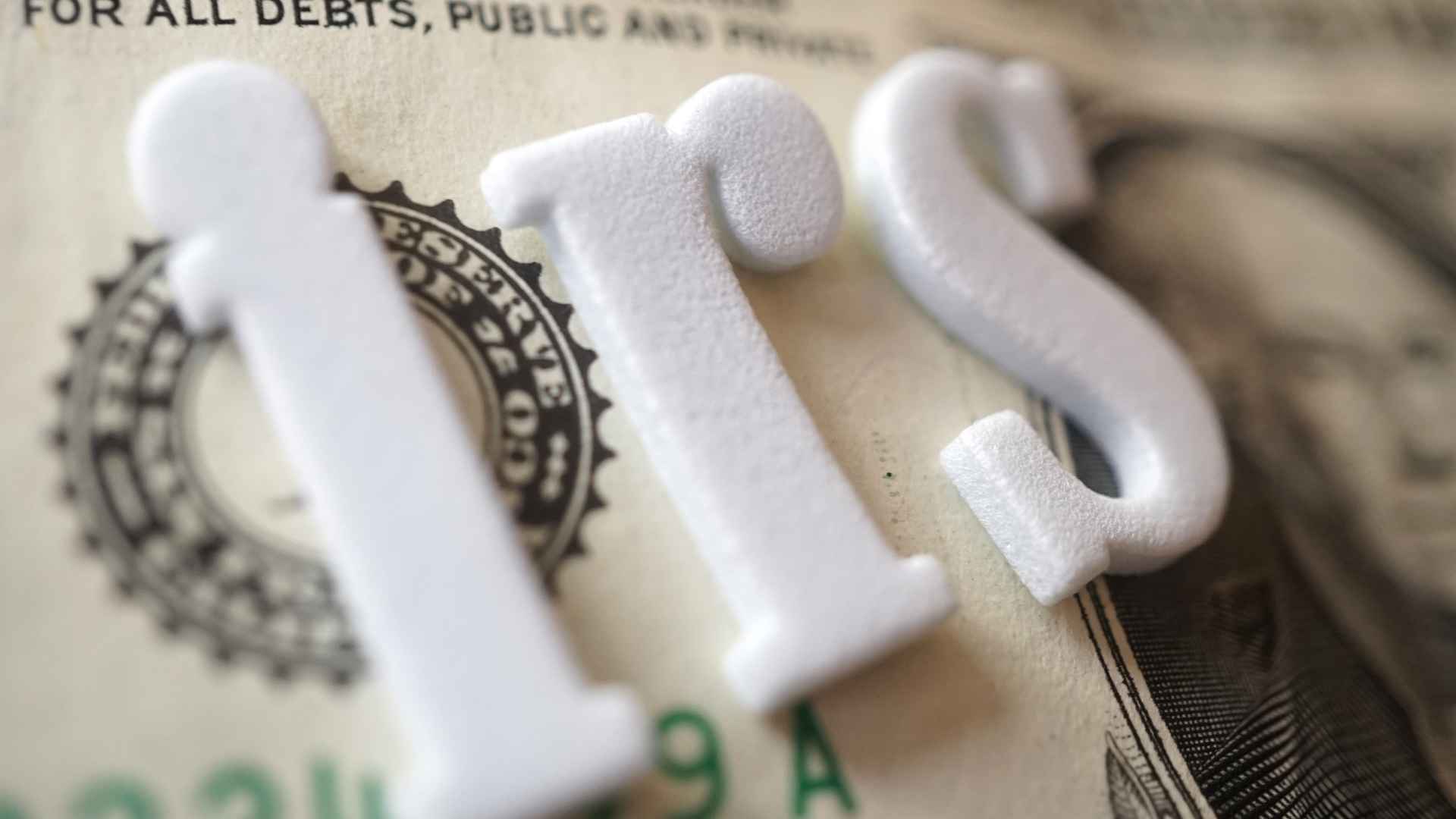 IRS letters on U.S. dollar bill illustrating 2025 tax-refund news and key eligibility requirements for up to $2,945