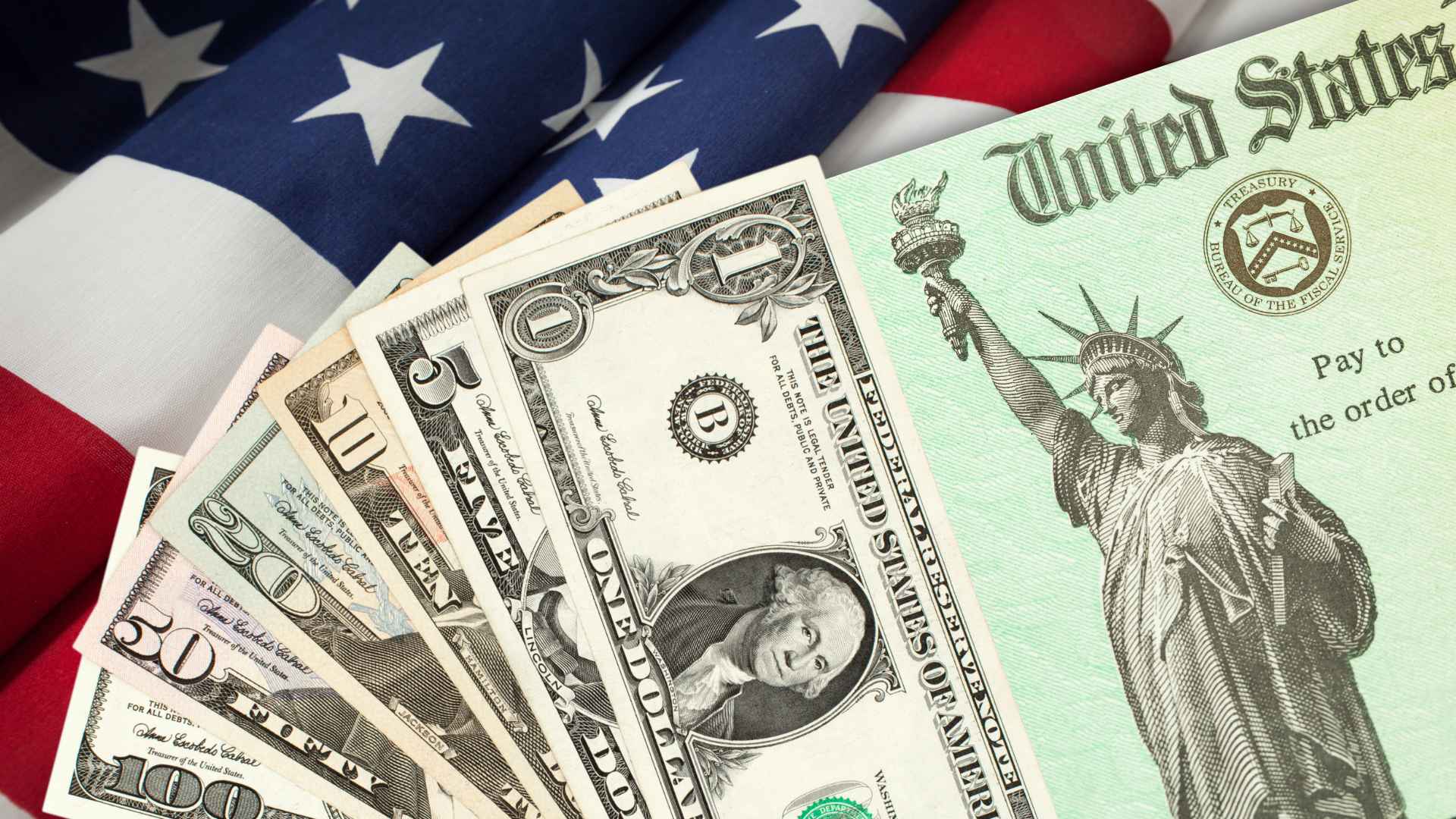 US Treasury check and dollar bills on American flag illustrate IRS switch from paper checks to direct deposit by 2025