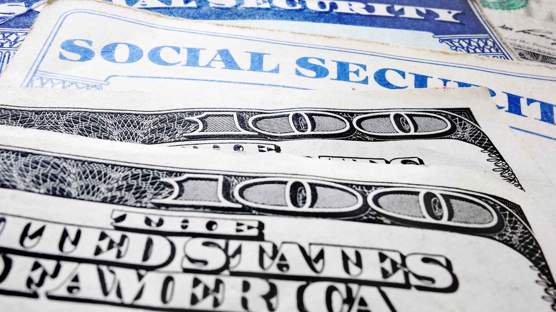 Close-up of Social Security cards and $100 bills symbolizing restored benefits for 2.8 million retirees under the new law