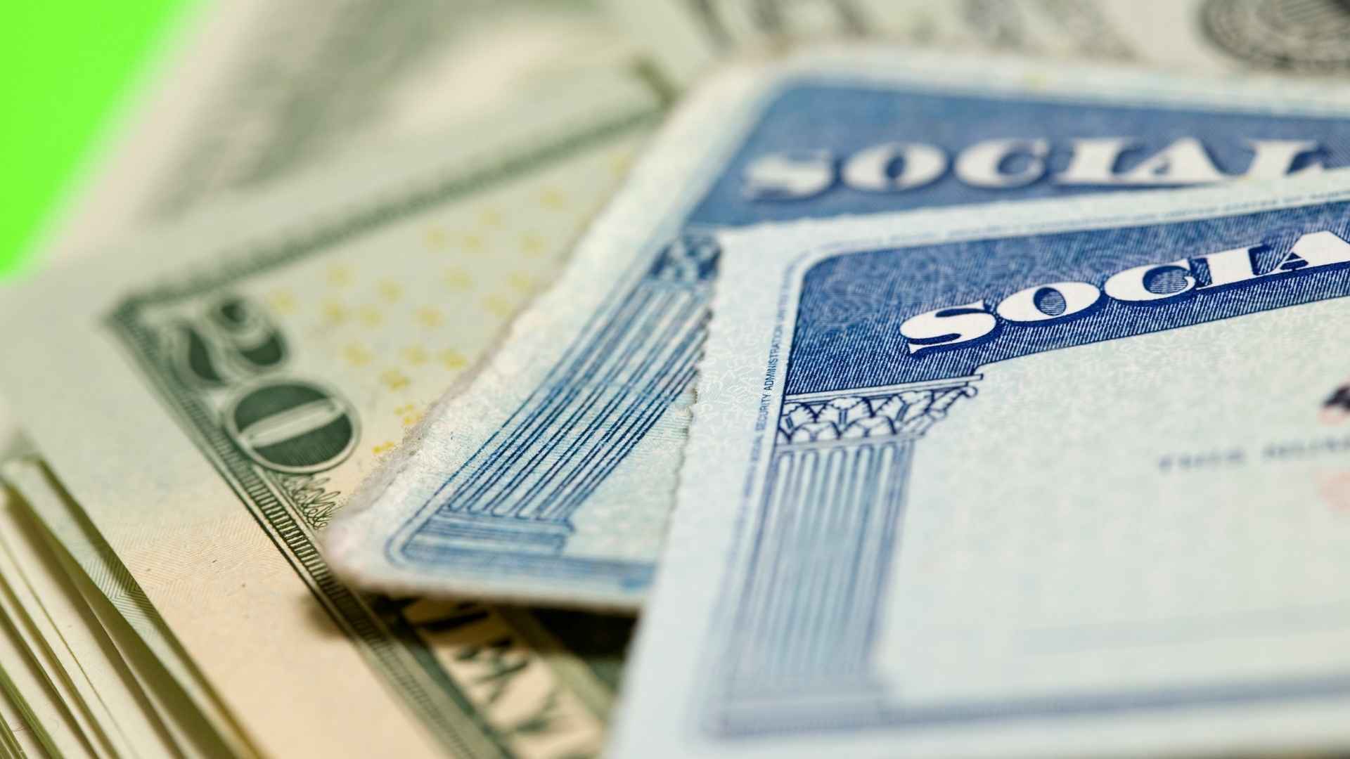 Close-up of Social Security cards and U.S. dollar bills symbolizing potential benefit cuts in 2033