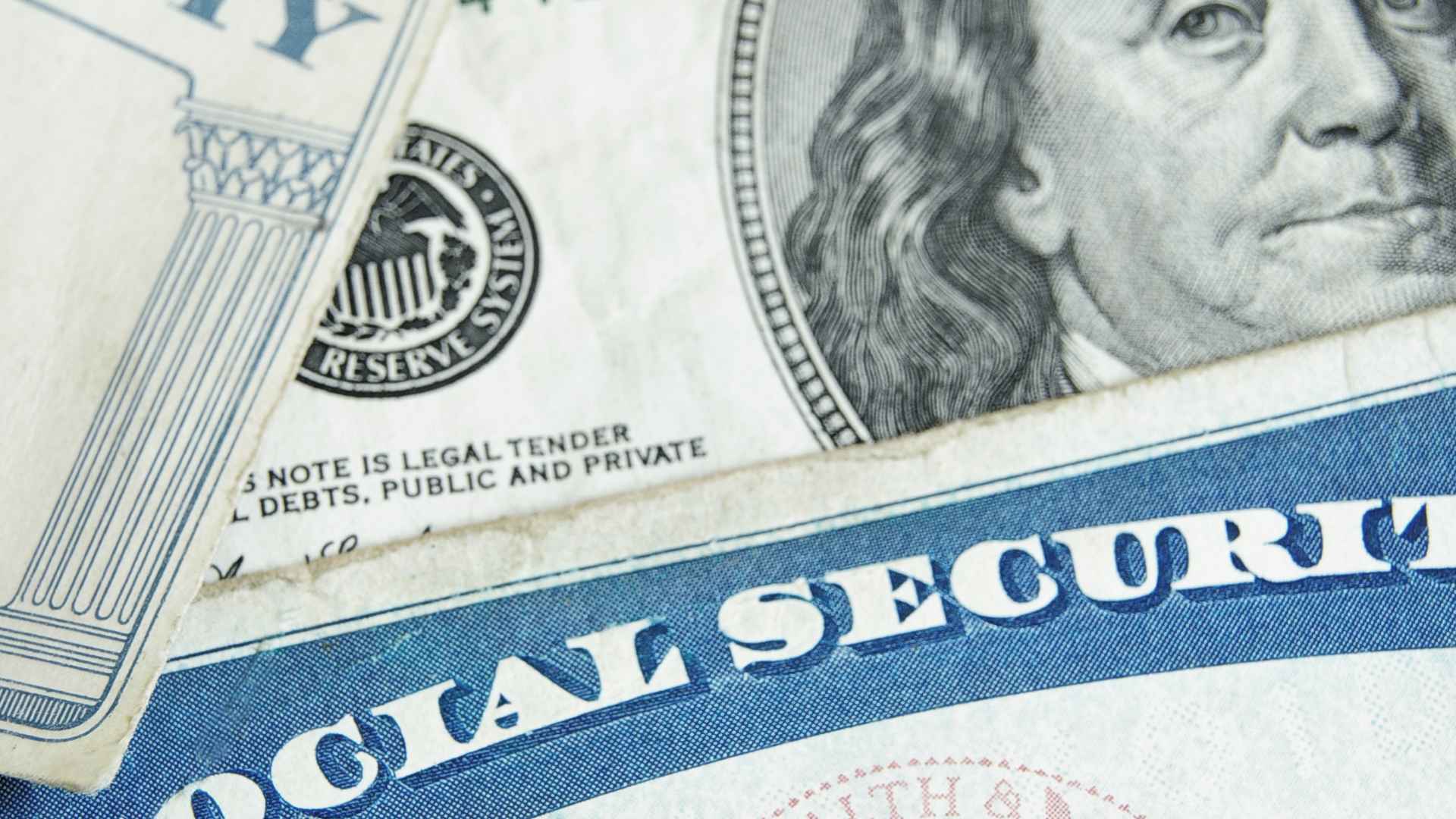 Social Security card atop $100 bill illustrating the six-figure salary needed for 2025’s $5,108 maximum benefit.