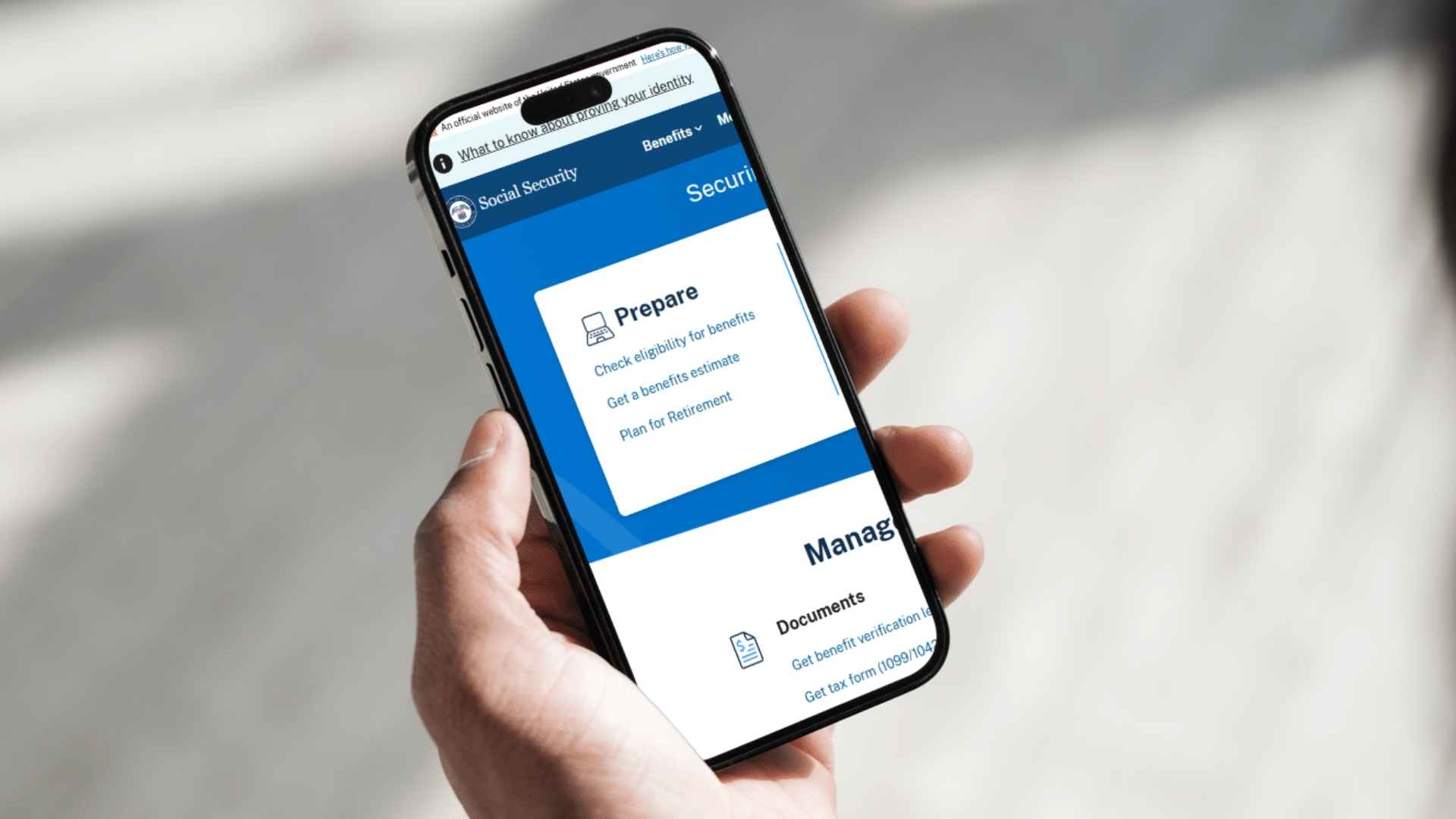 Hand holding smartphone showing Social Security Administration portal for enabling text alerts on benefit changes.
