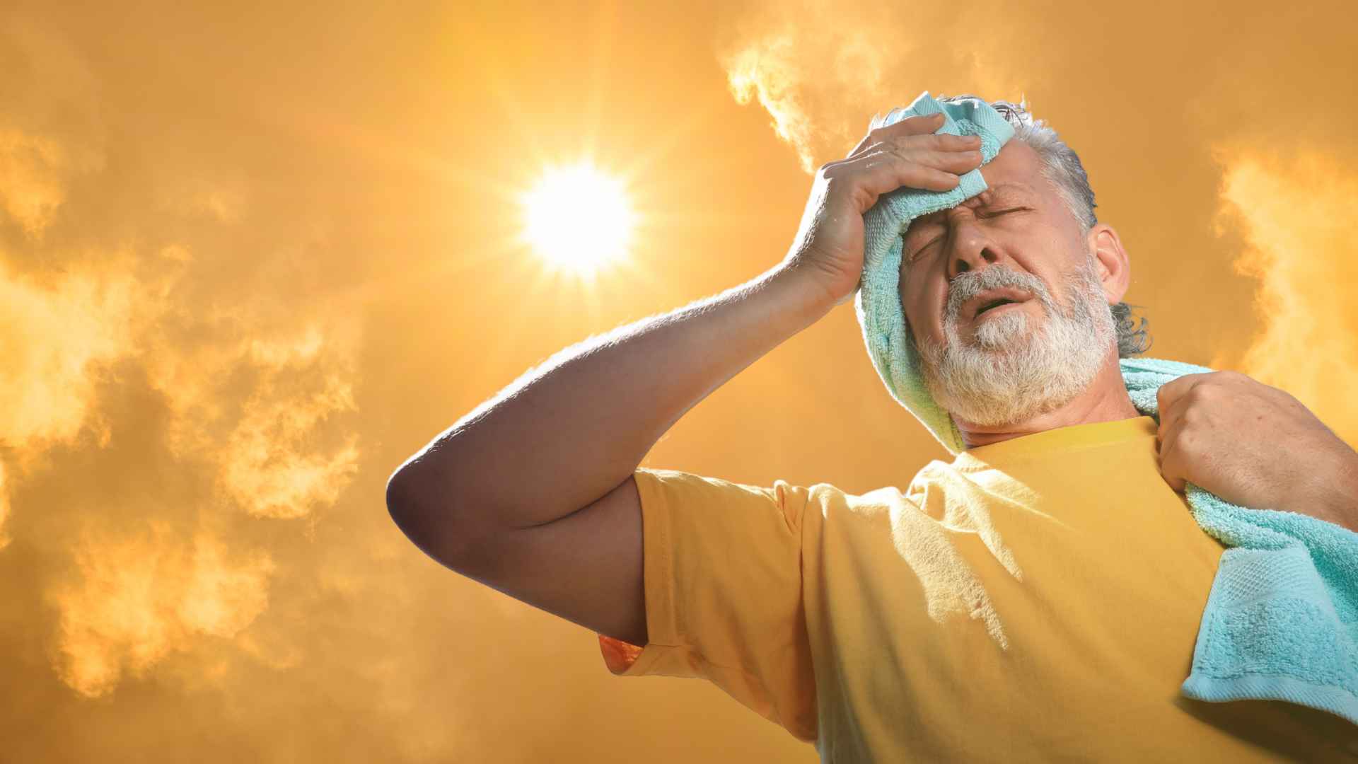 Man wipes sweat under intense sun during extreme heat alert