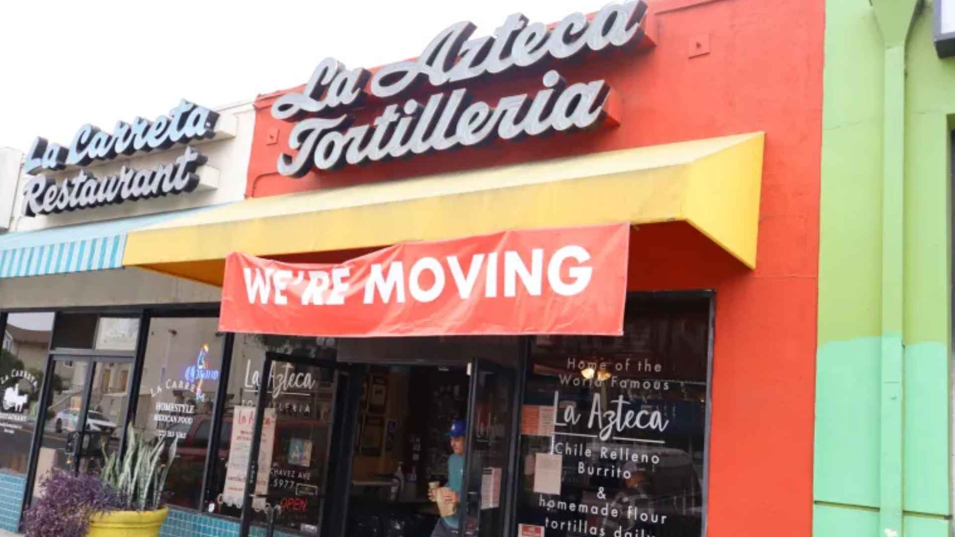 La Azteca Tortillería storefront in East Los Angeles with red “We’re Moving” banner announcing closure after 51 years.