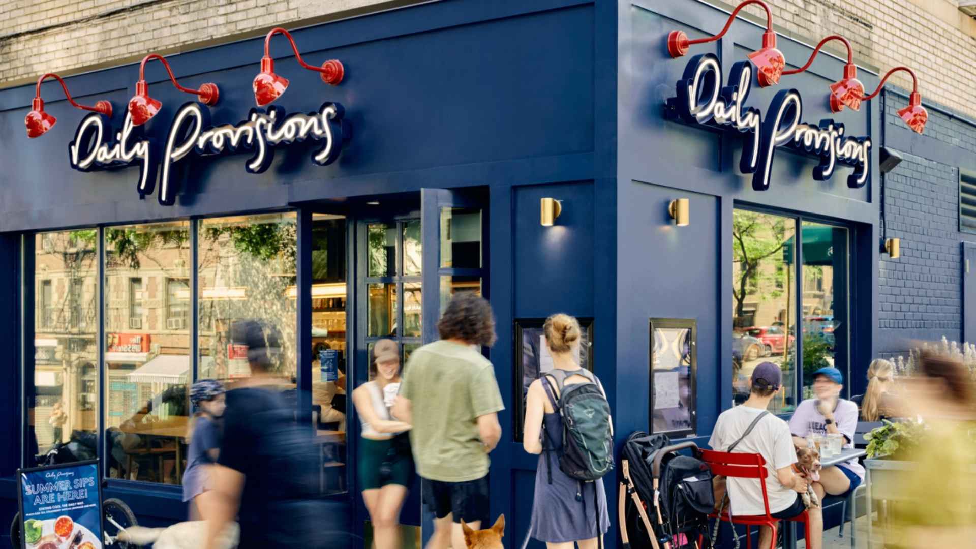 People gathered outside the newly opened Daily Provisions café in Harvard Square, Cambridge, enjoying opening-day specials.