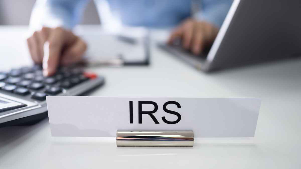 IRS desk with calculator and computer, showing IRS sign to signify charity verification tool use.
