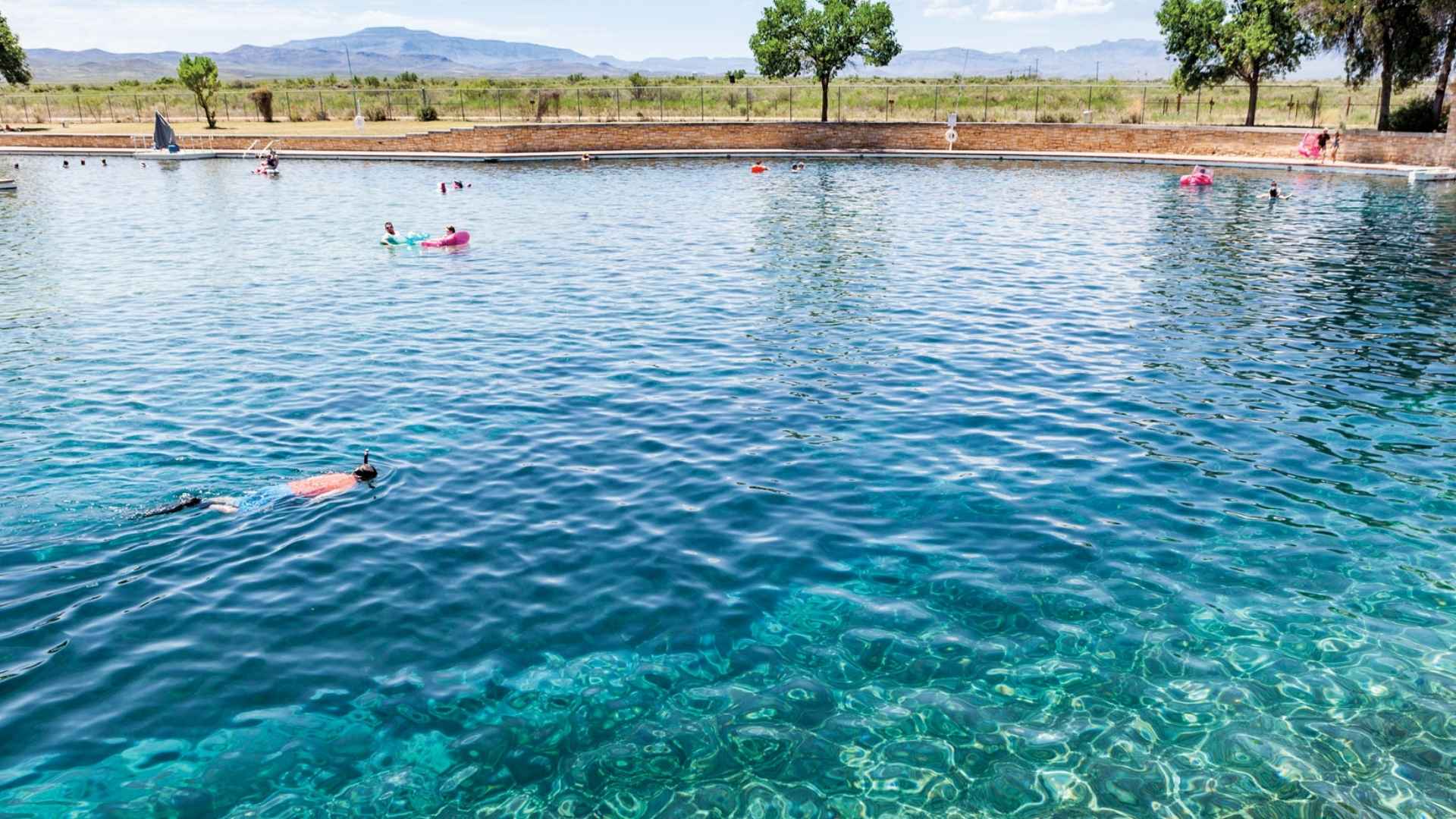 Person snorkeling in the crystal-clear waters of the world's largest spring-fed swimming pool at Balmorhea State Park, Texas