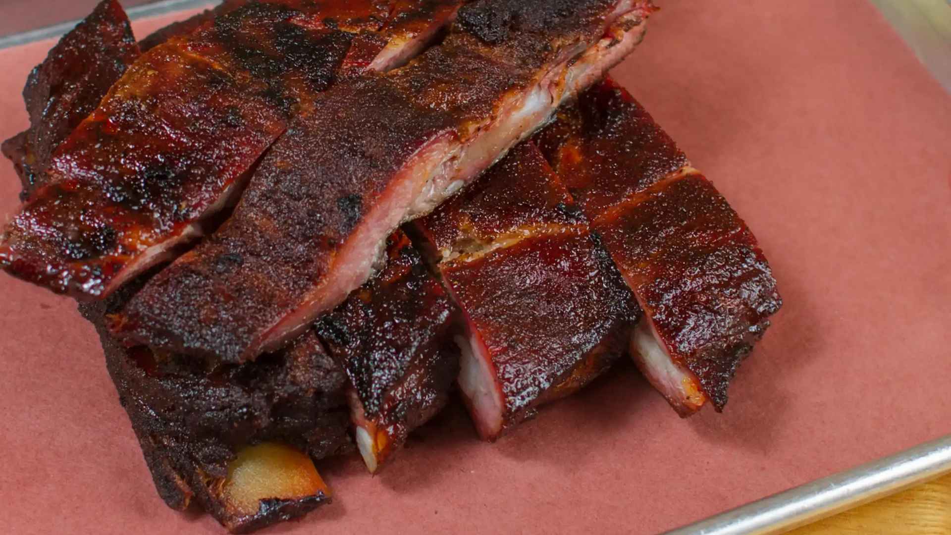 Close-up of glazed smoked pork ribs on butcher paper at an iconic los angeles barbecue restaurant closing after 23 years
