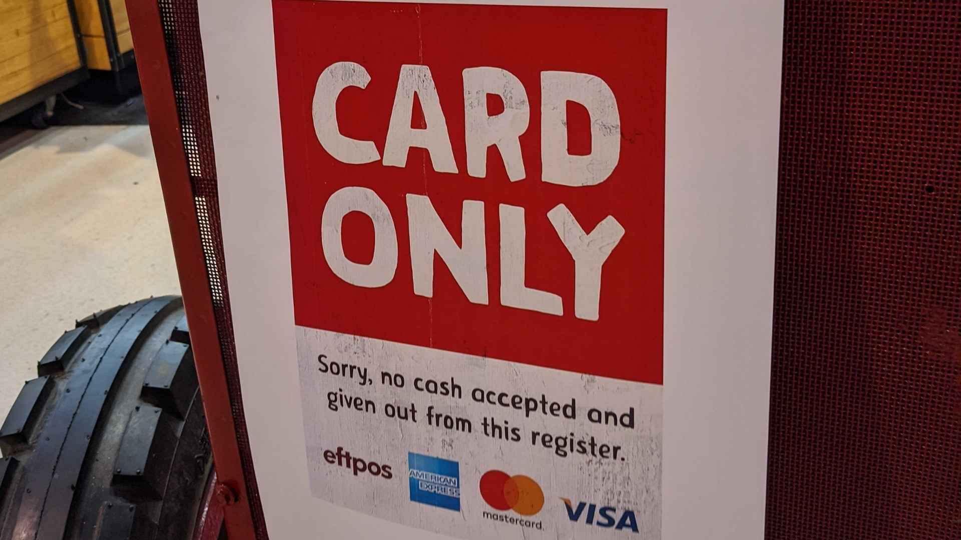 Sign in Miami-Dade store displaying card-only payment policy refusing cash payments