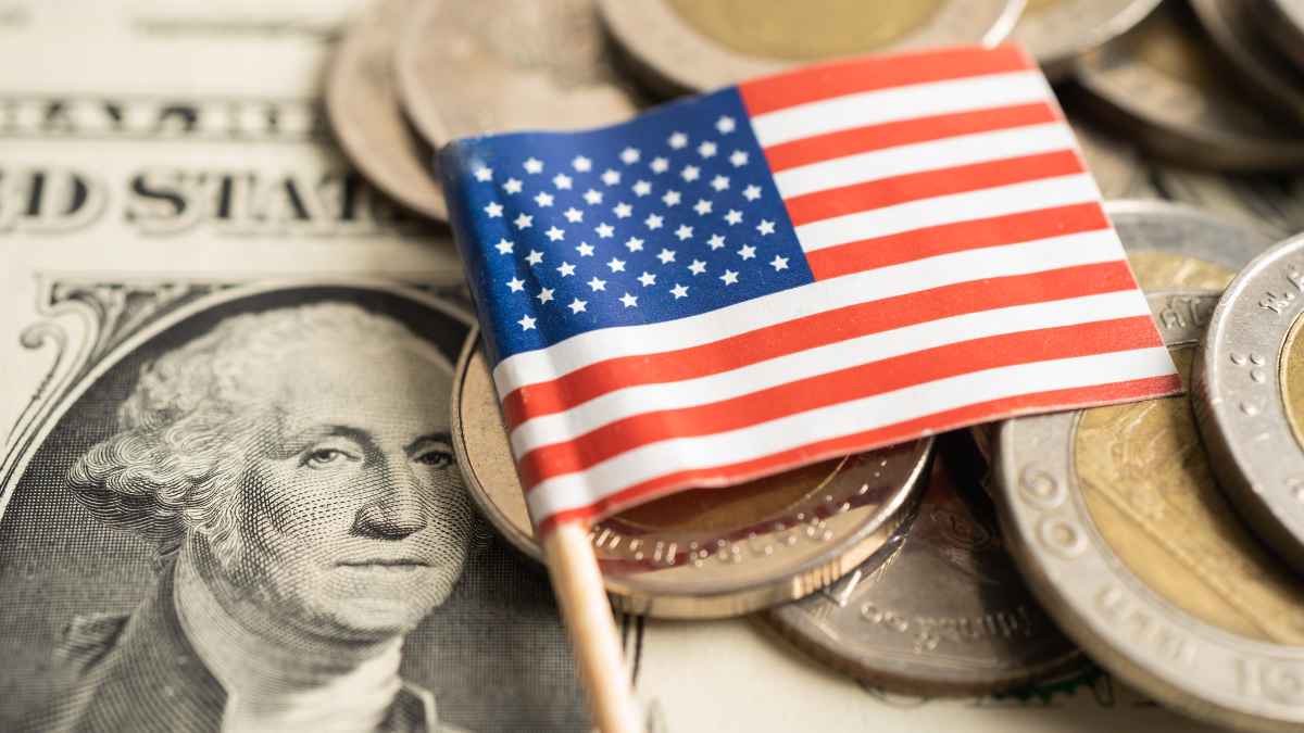 Close-up of U.S. dollar bill and coins with a small American flag, symbolizing financial planning for retirement.