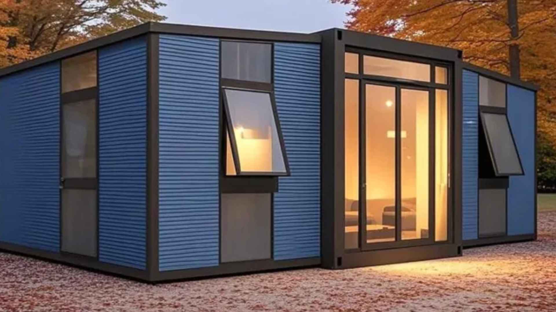 Amazon's modern cabin-style tiny house with large windows and cozy interior, placed in an autumn forest setting