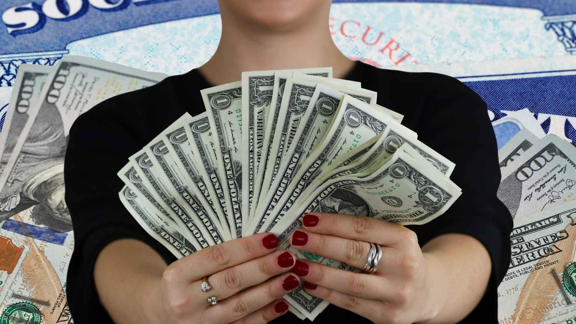 Woman holding cash with Social Security cards and money in background symbolizing higher checks for retirees