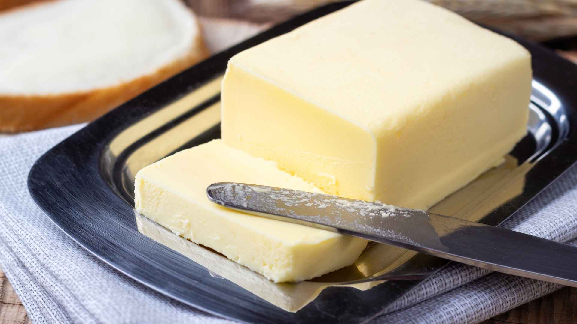 Block of butter on metal tray with knife, related to FDA Class II recall due to undeclared milk