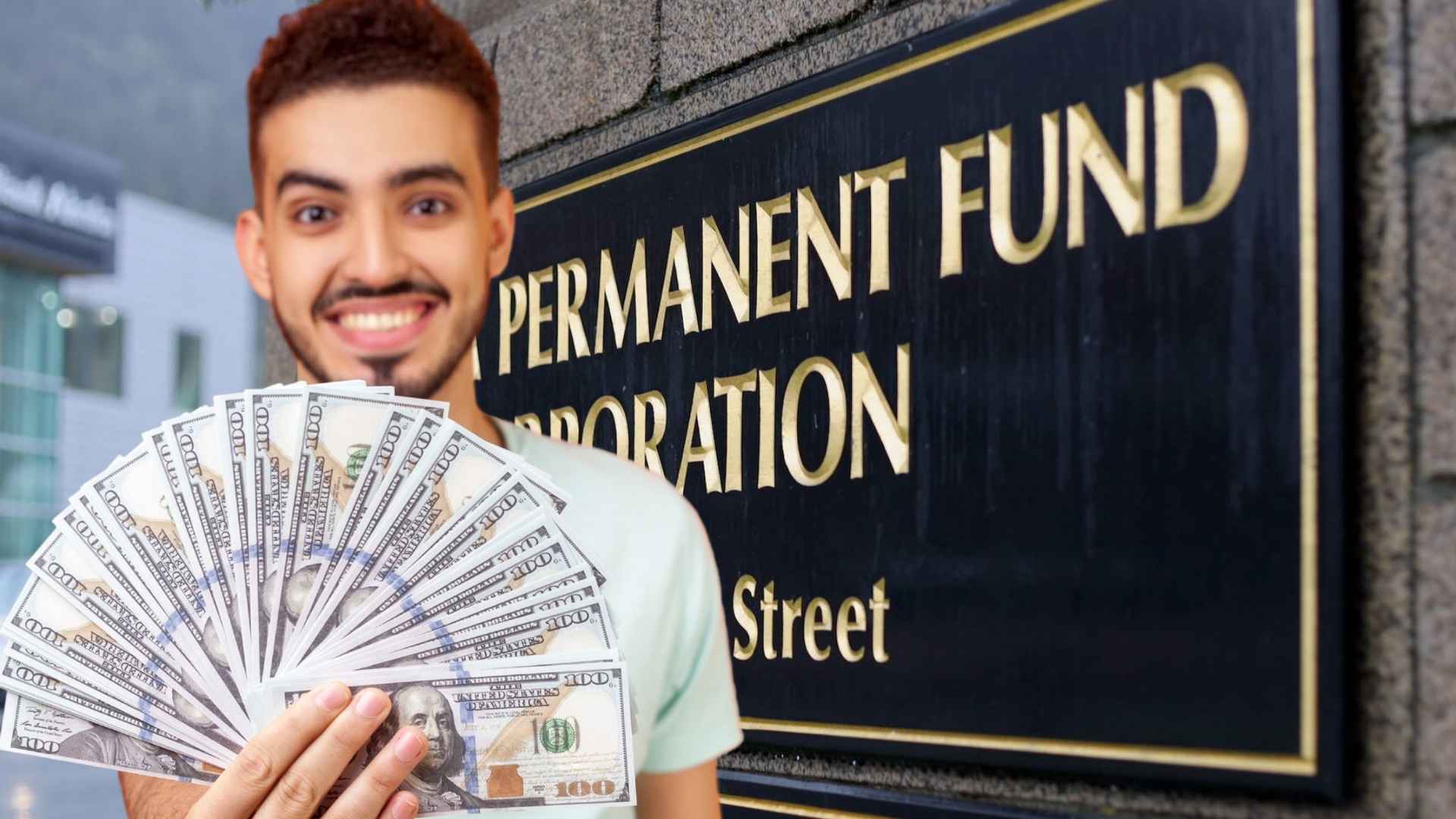 Smiling man holding dollar bills in front of Alaska Permanent Fund Corporation building awaiting $1,702 August payment