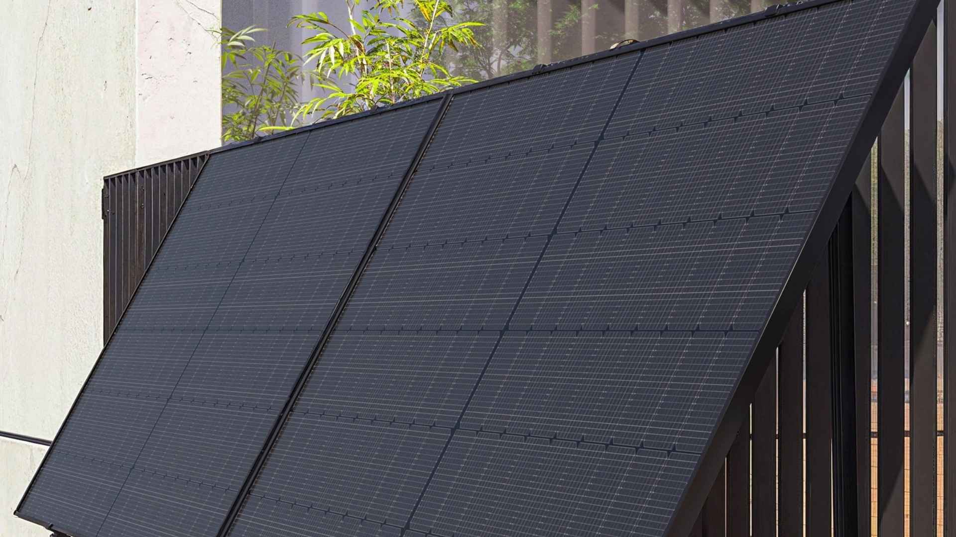 black photovoltaic fence panels on garden boundary generating solar power