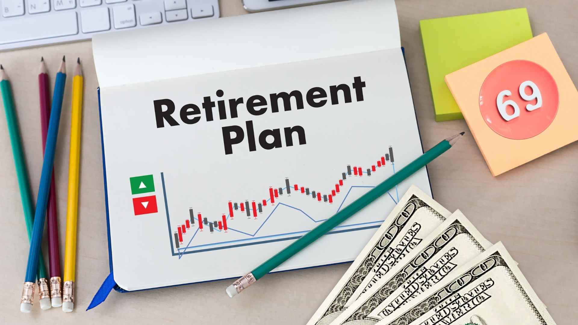 Notebook open to a page titled “Retirement Plan” showing a rising chart, colored pencils, U.S. dollar bills and a sticky note marked “69”