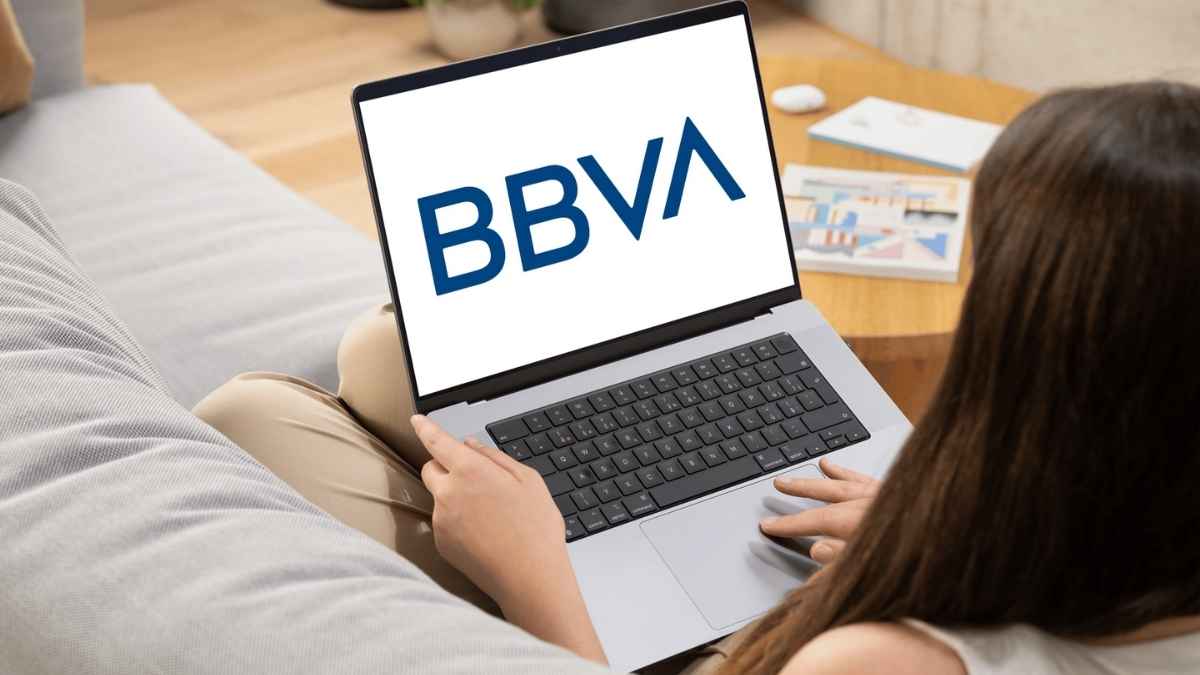 Mujer usando un portátil con el logo de BBVA en pantalla, representando oportunidades de empleo remoto e híbrido en BBVA.