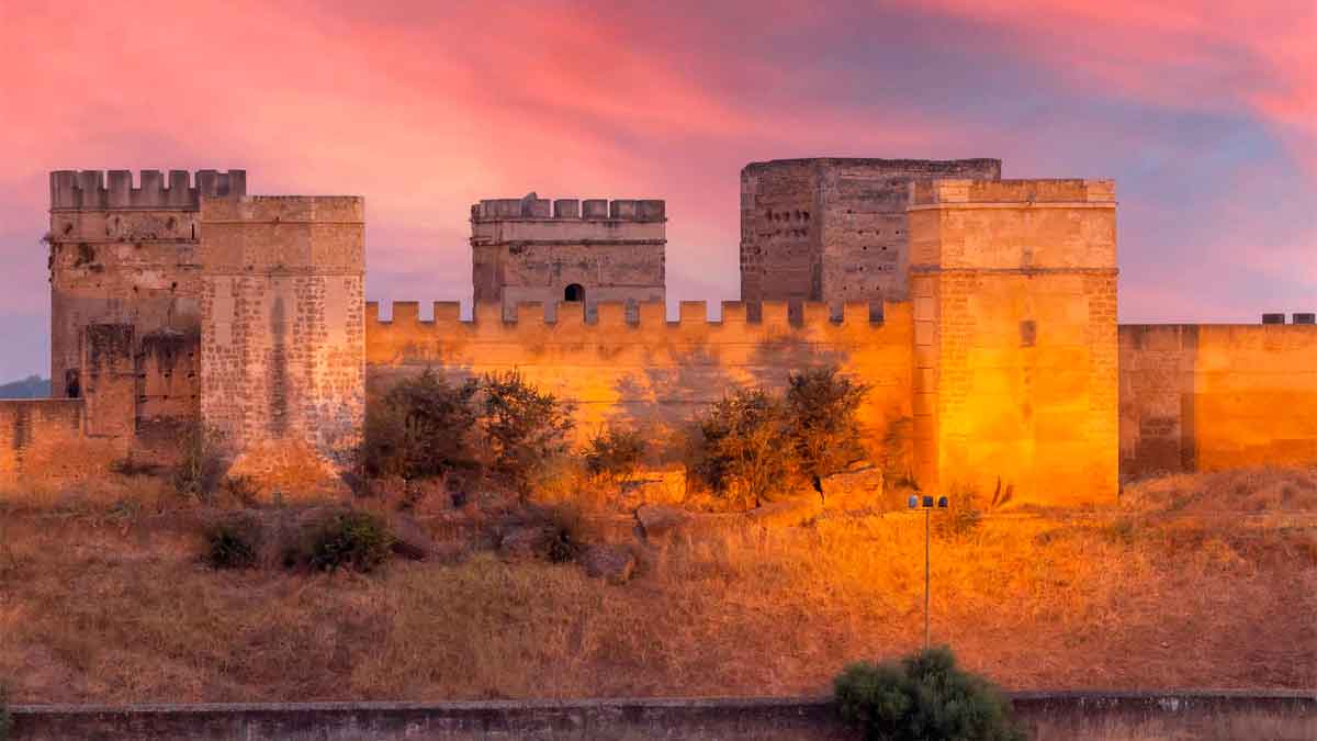 Muralla de Alcalá de Guadaíra al atardecer, cerca de Sevilla, destacando su patrimonio histórico y oferta laboral en Kik