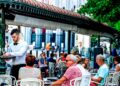 Camarero atendiendo en la terraza de un restaurante concurrido, ejemplo de empleo en bares y restaurantes en España