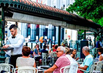 Camarero atendiendo en la terraza de un restaurante concurrido, ejemplo de empleo en bares y restaurantes en España