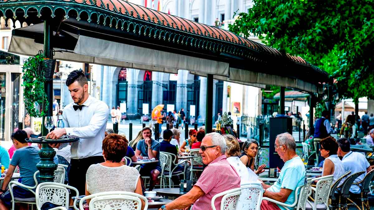 Camarero atendiendo en la terraza de un restaurante concurrido, ejemplo de empleo en bares y restaurantes en España