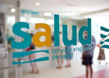 Logotipo del Servicio Aragonés de Salud en el cristal de una puerta, con personas en el interior del centro sanitario.