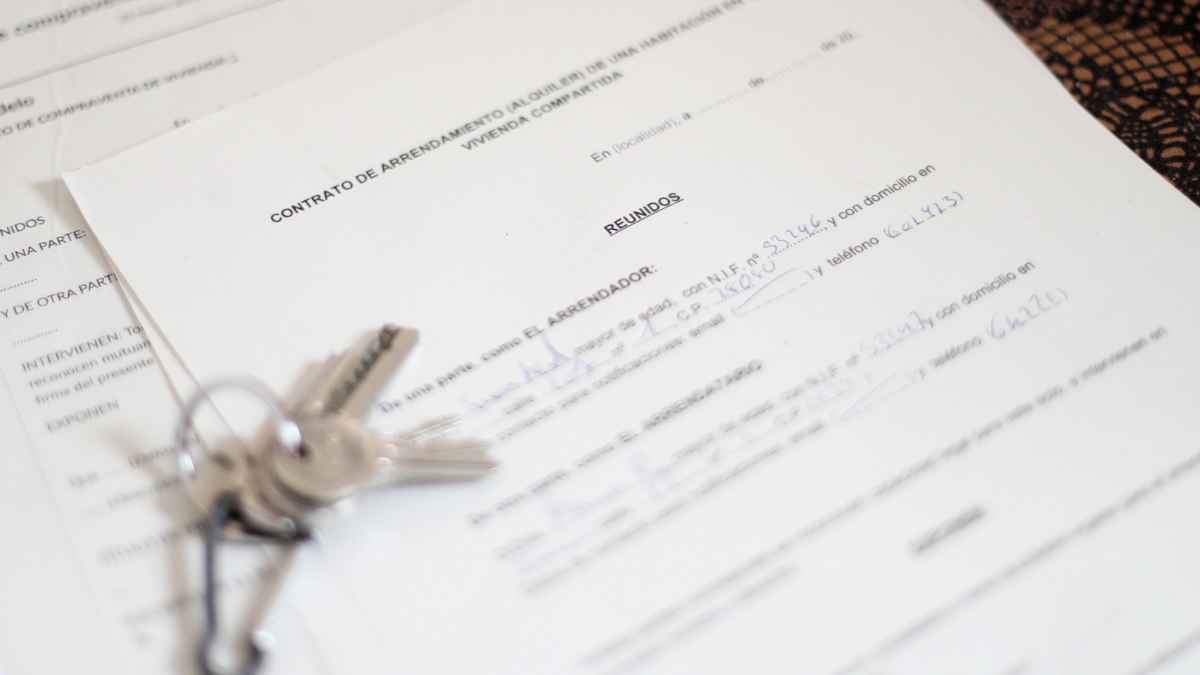 Llaves sobre un contrato de arrendamiento de vivienda habitual, imagen representativa de la deducción por alquiler en la declaración de la Renta de Madrid.